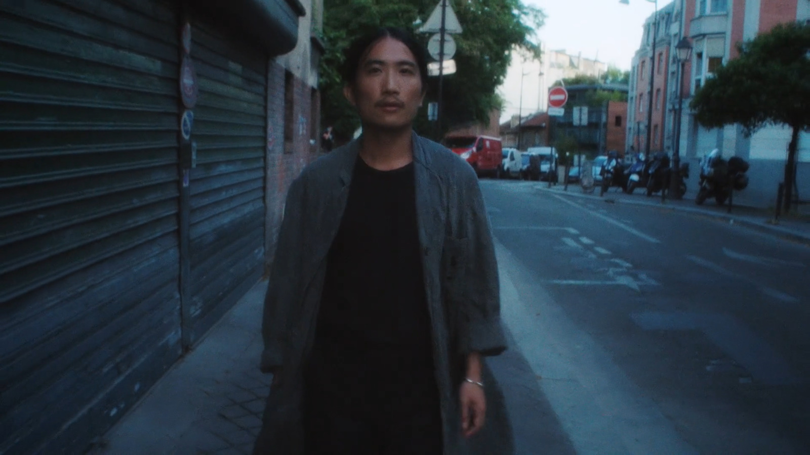 a man standing on the side of a street next to a building