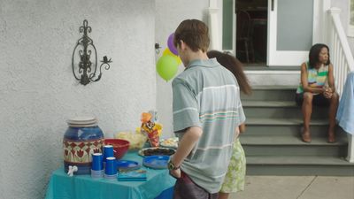 a boy and a girl standing outside of a house