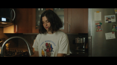 a woman standing in a kitchen next to a refrigerator