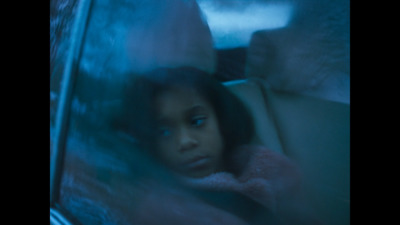 a young girl sitting in the back seat of a car