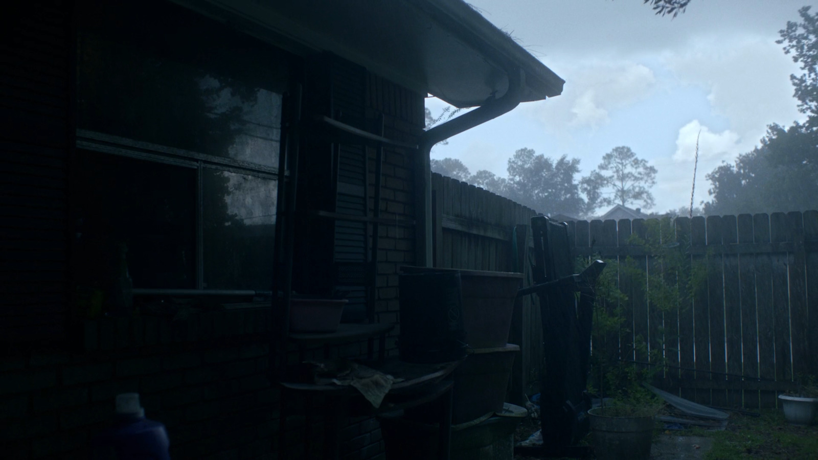 a dark picture of a back yard with a fence