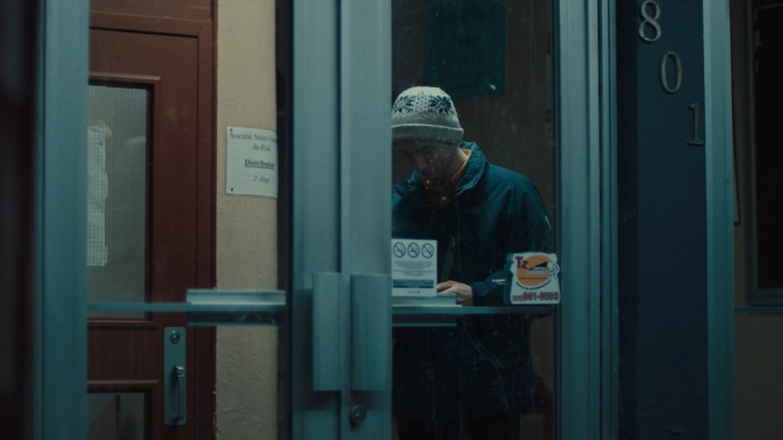 a man standing in front of a door with a cup of coffee