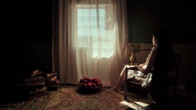 a woman sitting in a chair in front of a window