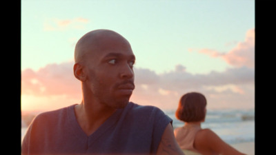 a man and a woman on the beach at sunset