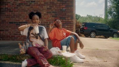 a couple of women sitting on the side of a road