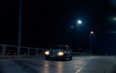 a car driving down a street at night