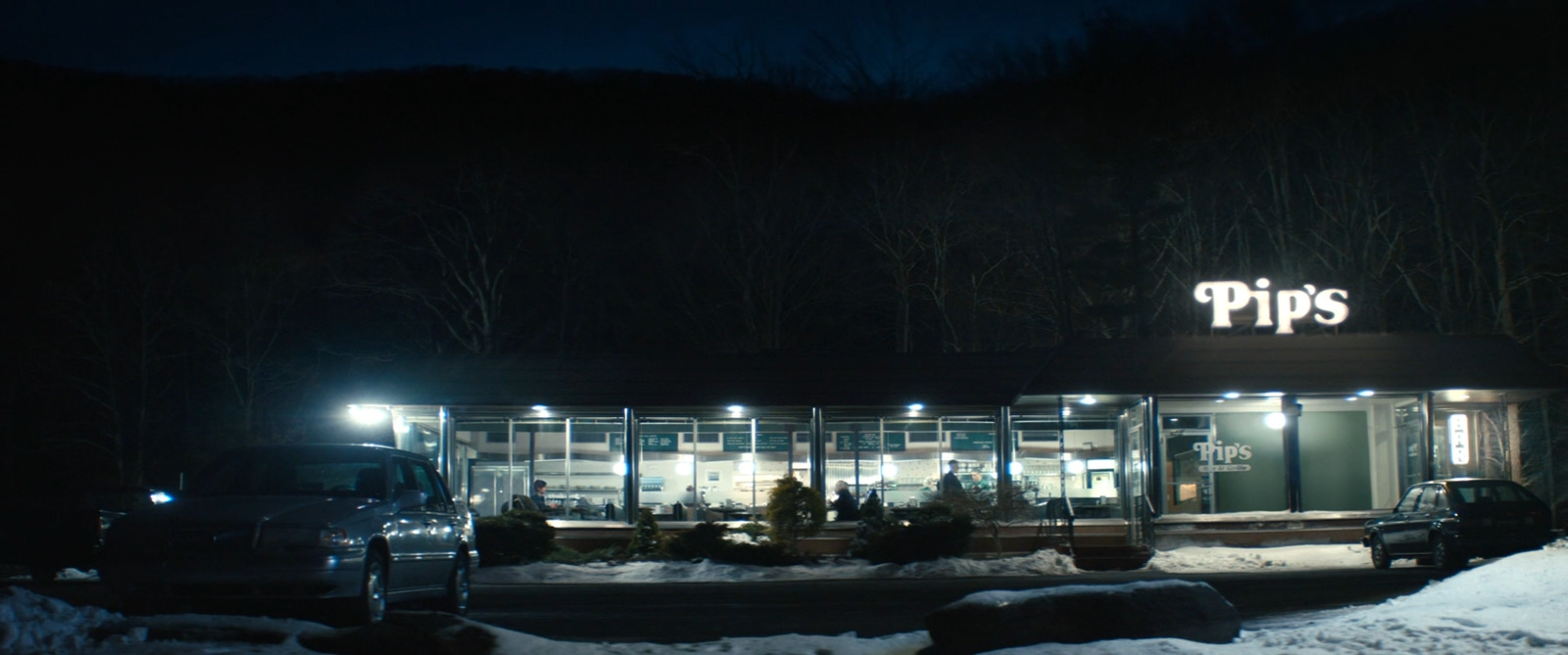 a car parked in front of a store at night