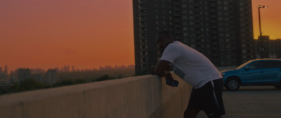 a man leaning against a wall with a skateboard