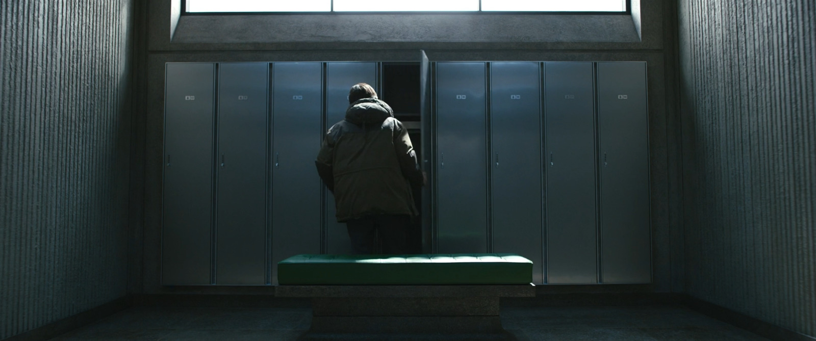 a person standing in a room with a green bench