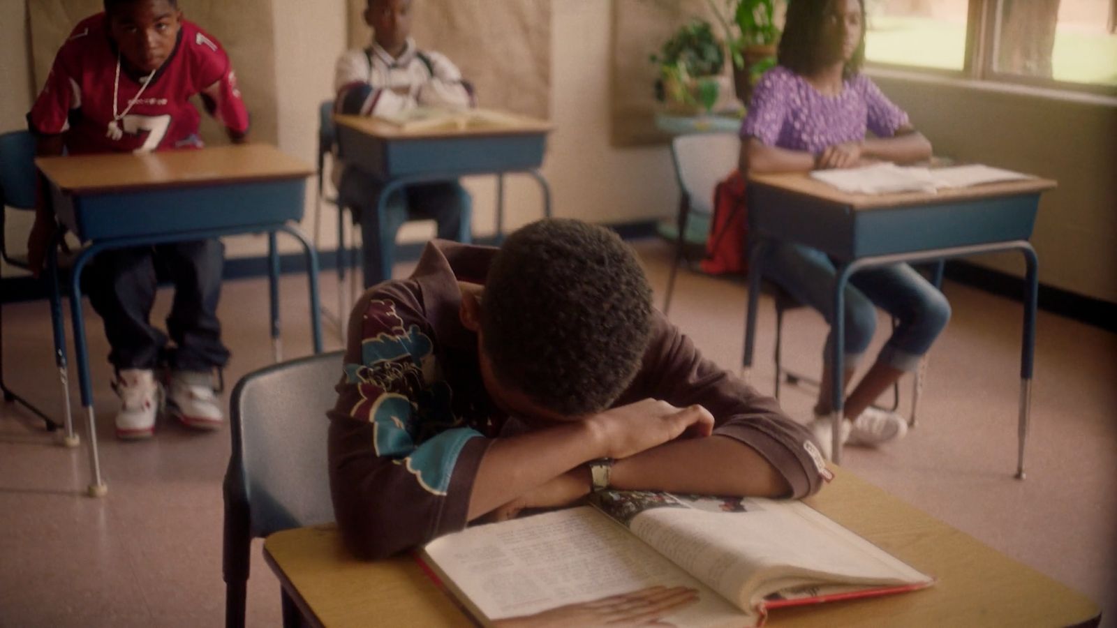 a group of kids sitting at desks in a classroom