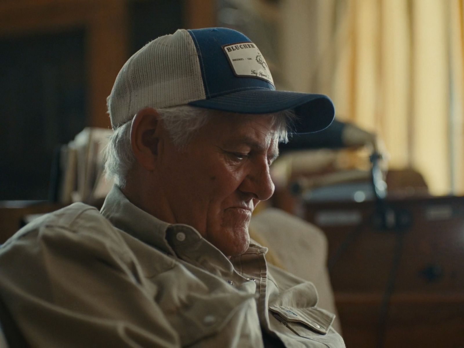 a man sitting in a chair wearing a hat