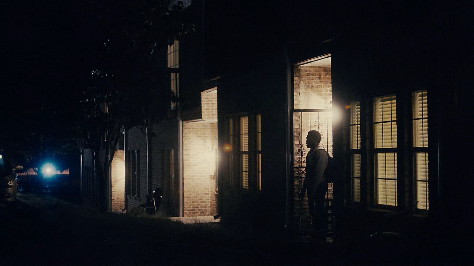 a person standing outside of a building at night