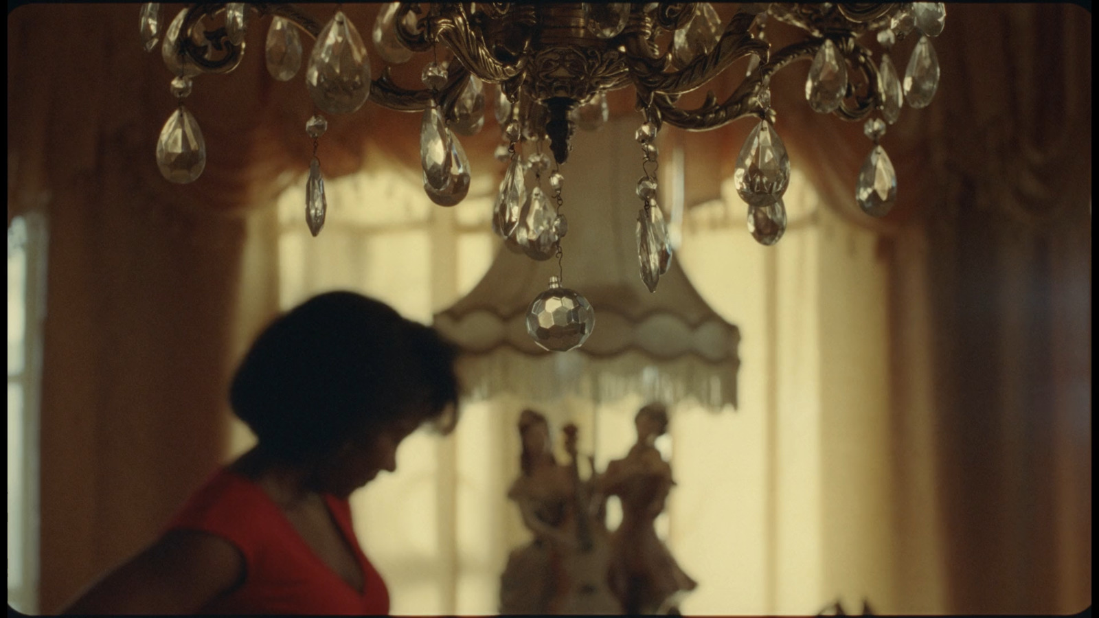 a woman standing in front of a chandelier