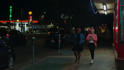 a couple of women walking down a street at night