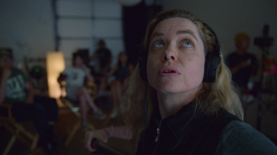 a woman with headphones in front of a group of people