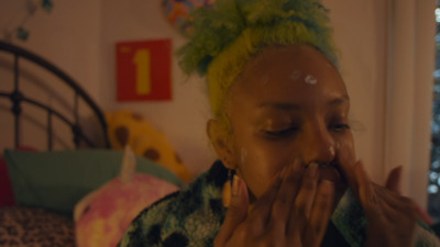 a woman with green hair covers her mouth