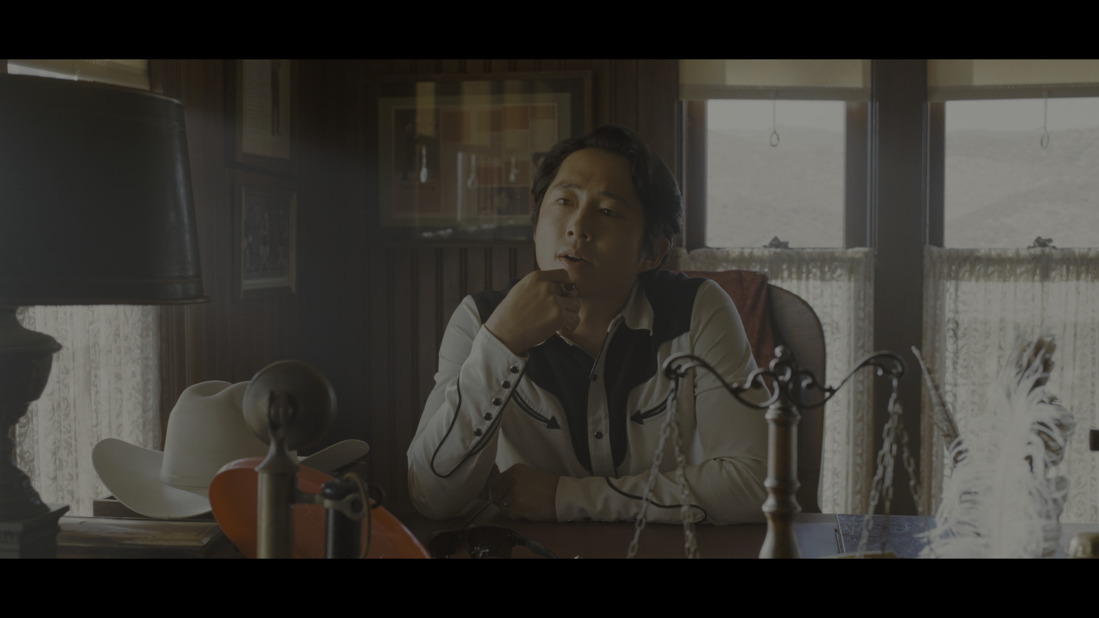 a man sitting at a desk in front of a lamp