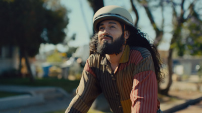 a man with long hair and a beard riding a bike