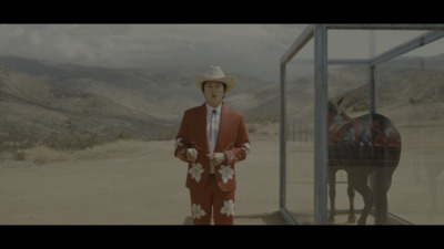 a man in a red suit and cowboy hat