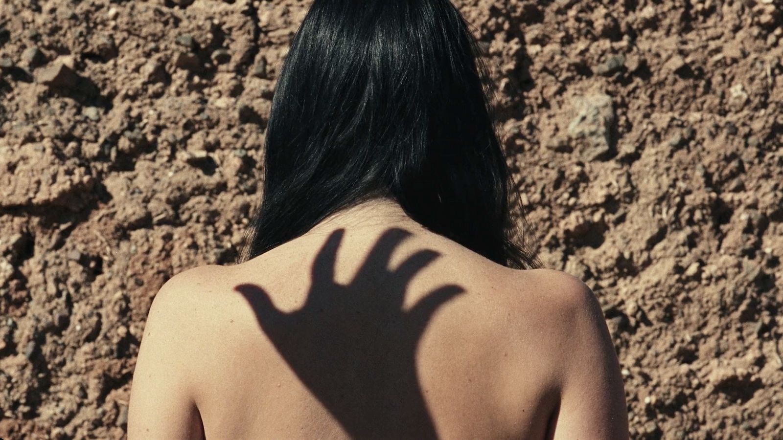 a woman with a shadow of a hand on her back