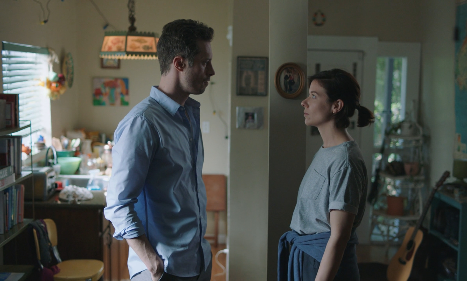 a man standing next to a woman in a kitchen