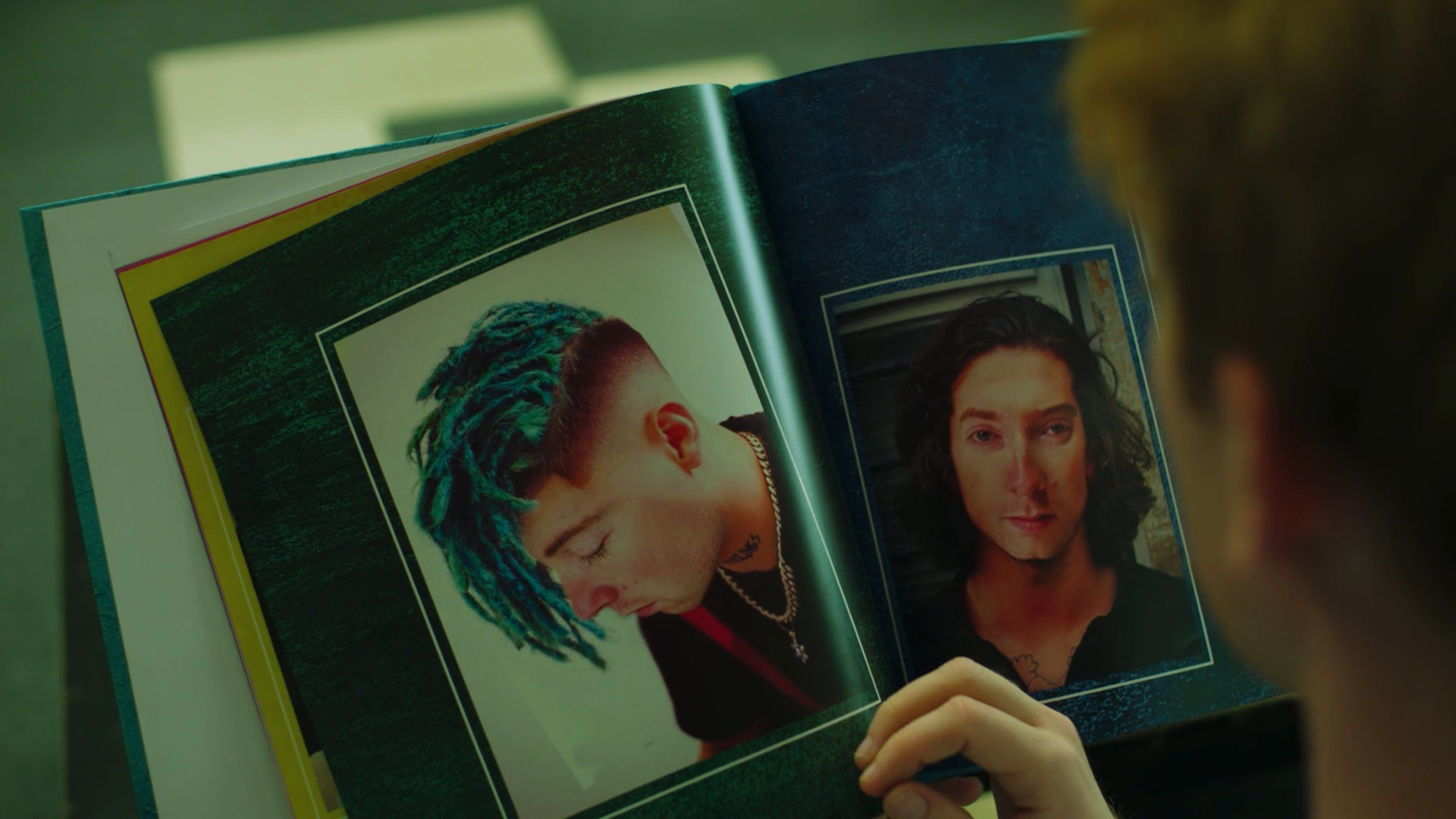 a person holding a book open to a picture of a woman with dreadlocks