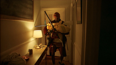 a man with a sword standing in a hallway