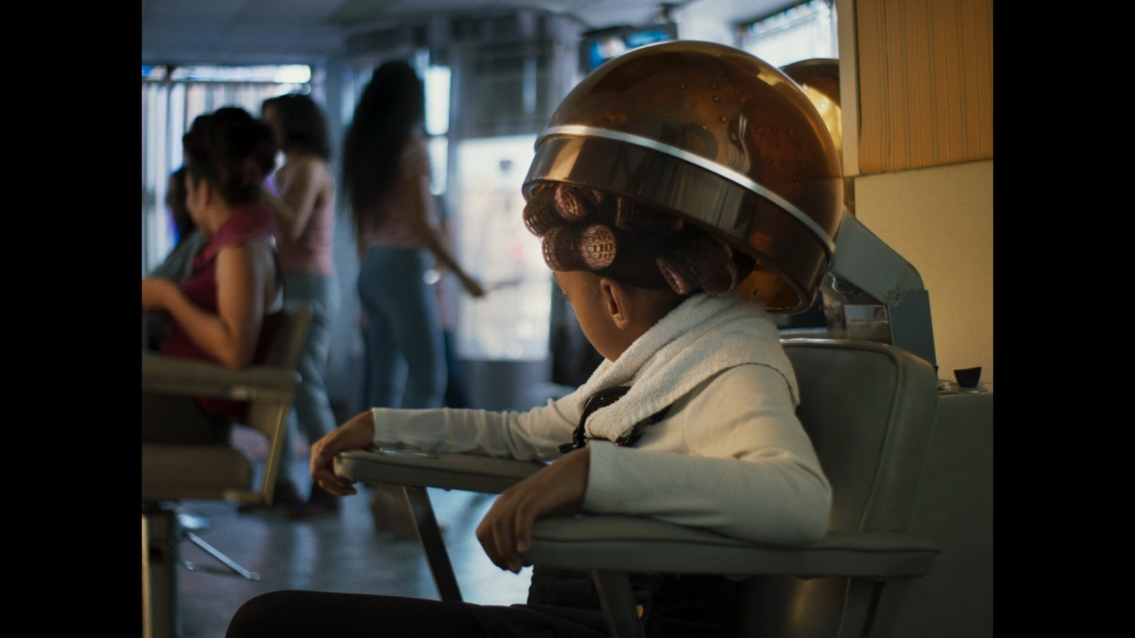 a woman sitting in a chair with a helmet on her head