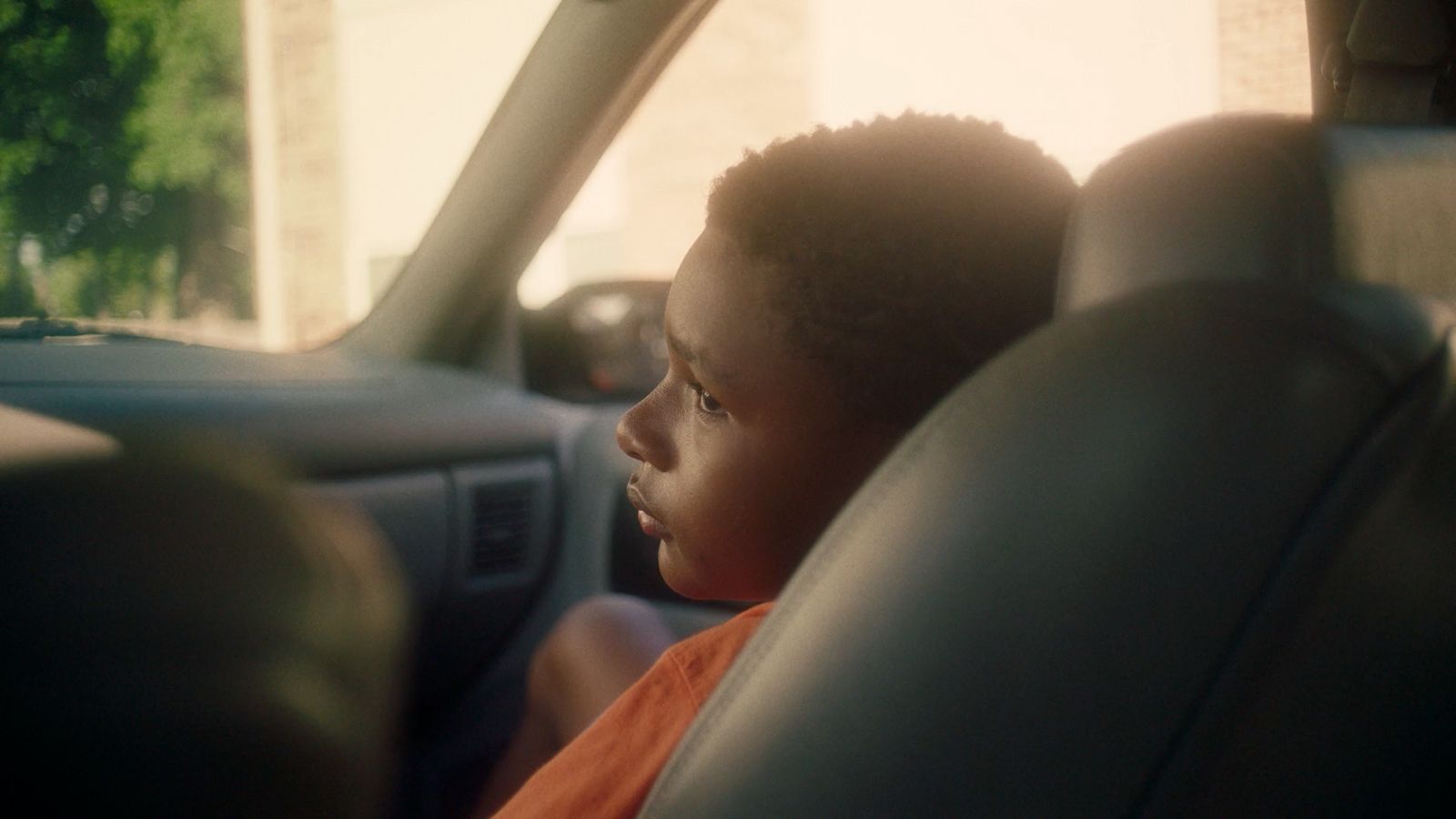 a little boy sitting in the back seat of a car