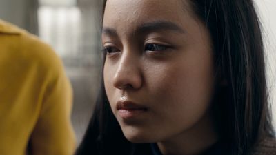 a close up of a person wearing a yellow shirt