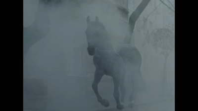 a horse running through a foggy street