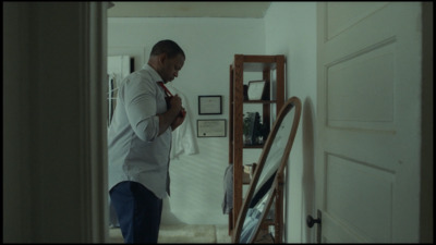 a man in a white shirt is standing in a hallway