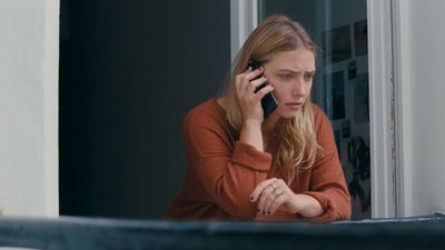 a woman sitting at a table talking on a cell phone