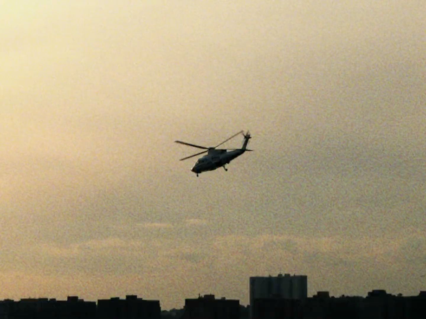 a helicopter flying in the sky over a city