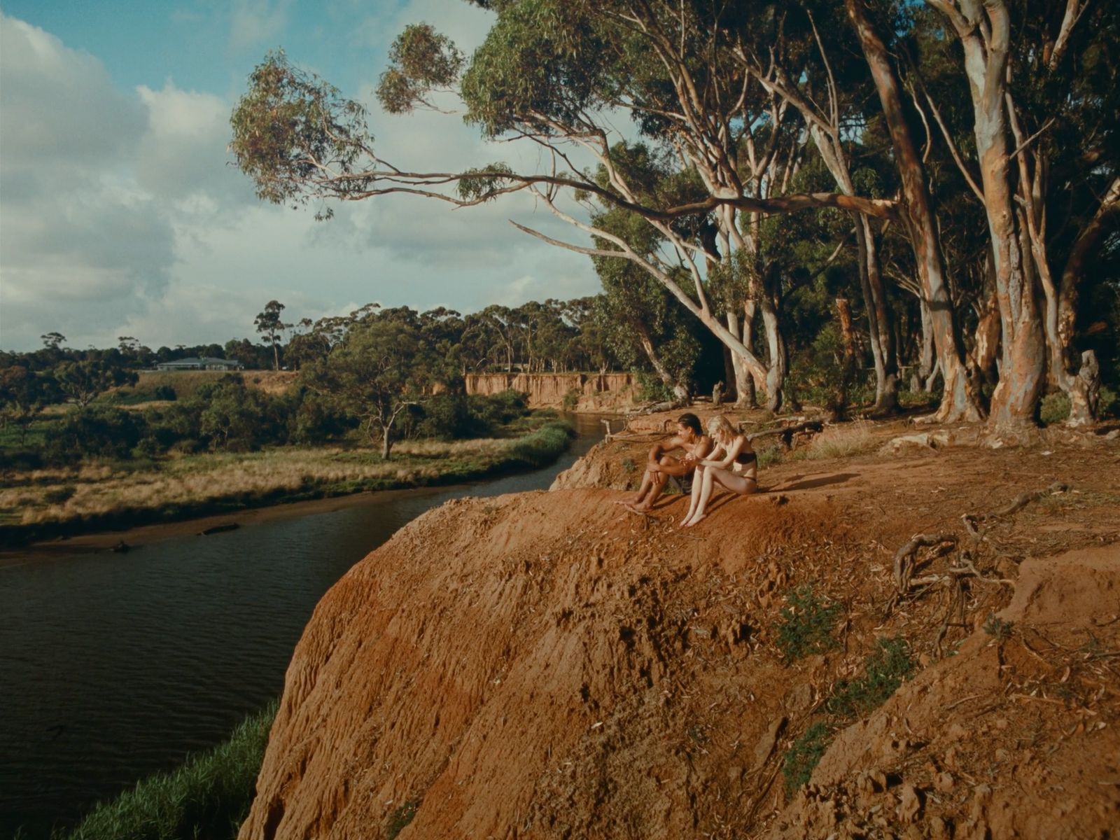 a couple of people sitting on top of a cliff