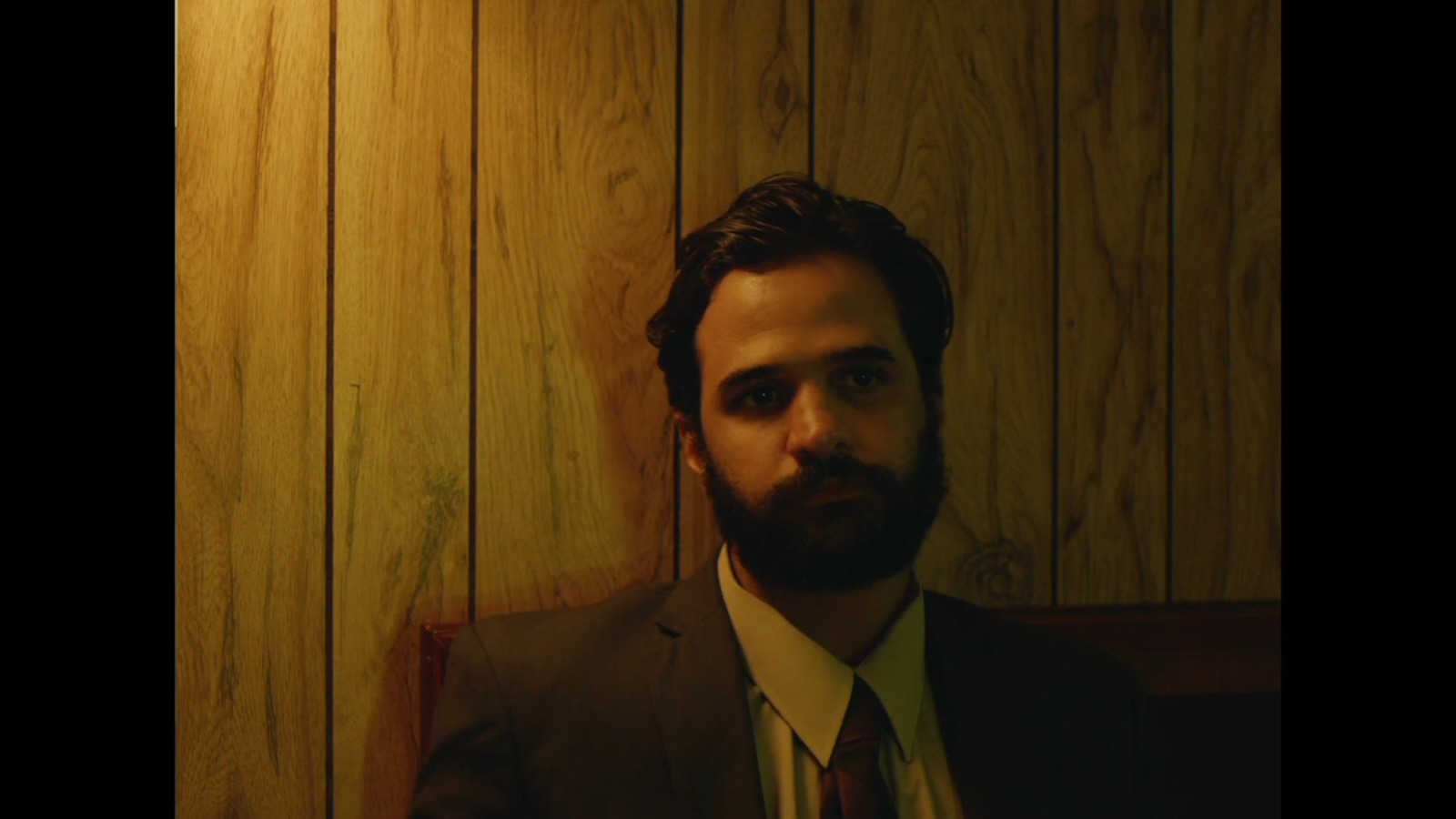 a man with a beard wearing a suit and tie