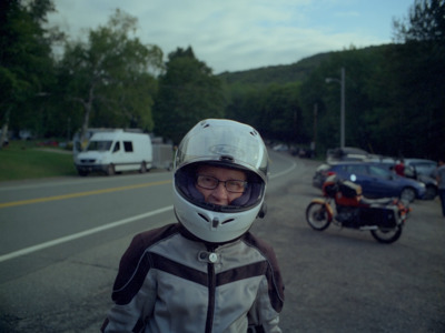 a man wearing a helmet standing next to a motorcycle