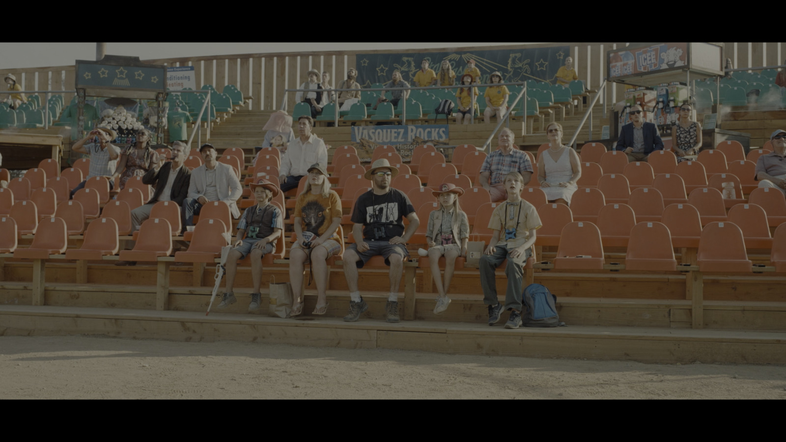 a group of people sitting on top of a bleachers