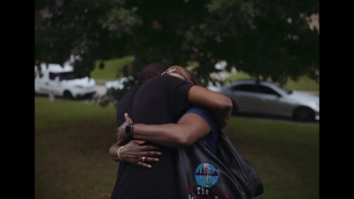 two people hugging each other in a park