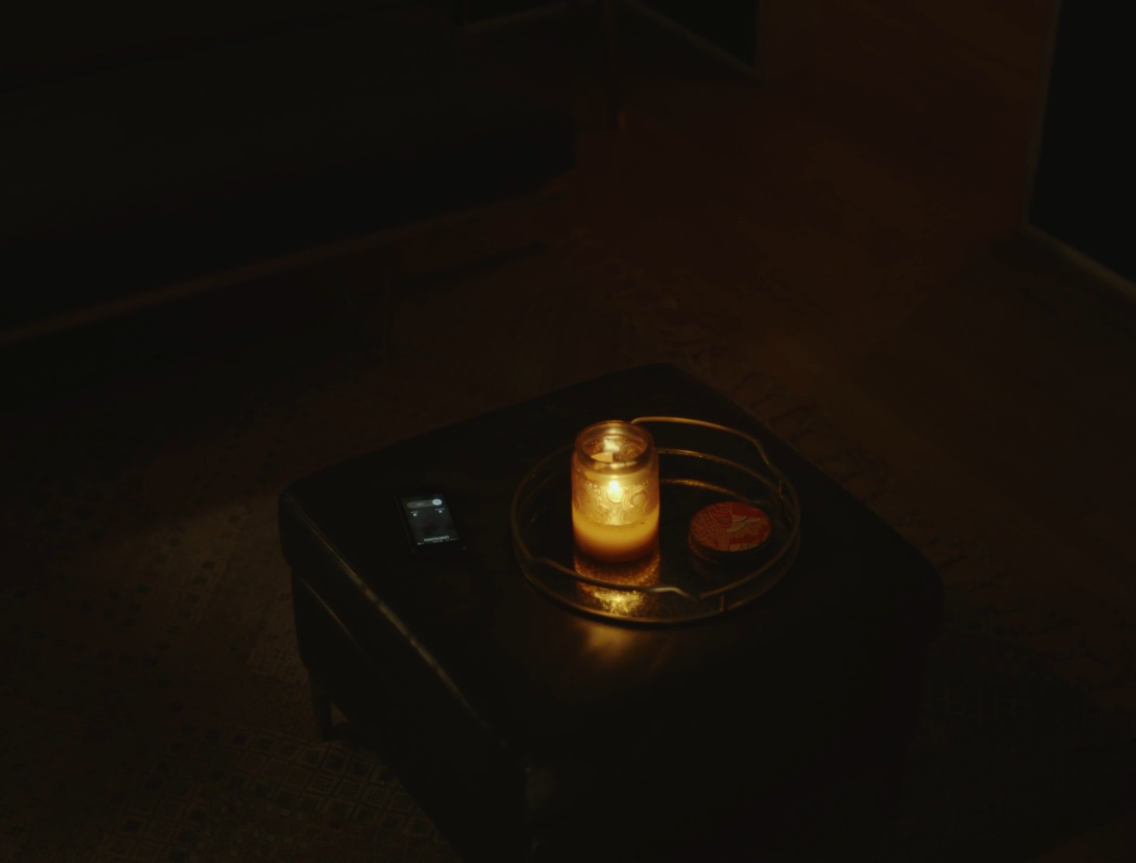 a lit candle sitting on top of a black suitcase