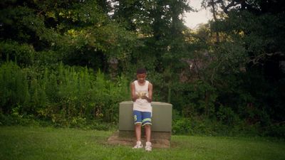 a person sitting on a bench in the grass