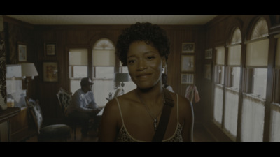 a woman standing in a living room next to a window