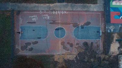 an aerial view of a basketball court with graffiti on it