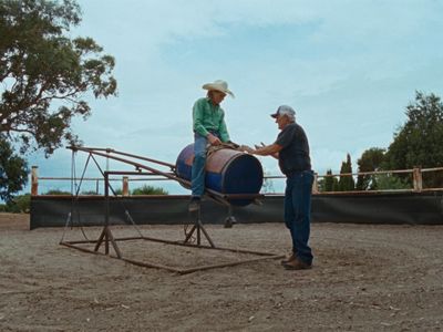 a man in a cowboy hat shaking hands with a man in a green shirt