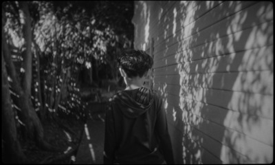 a young boy standing next to a wall