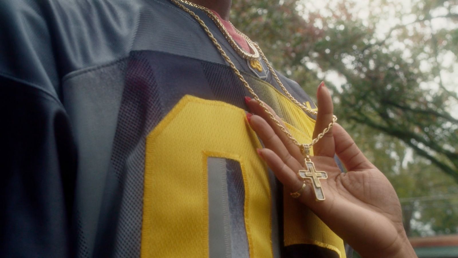 a person wearing a yellow and black jersey holding a cross