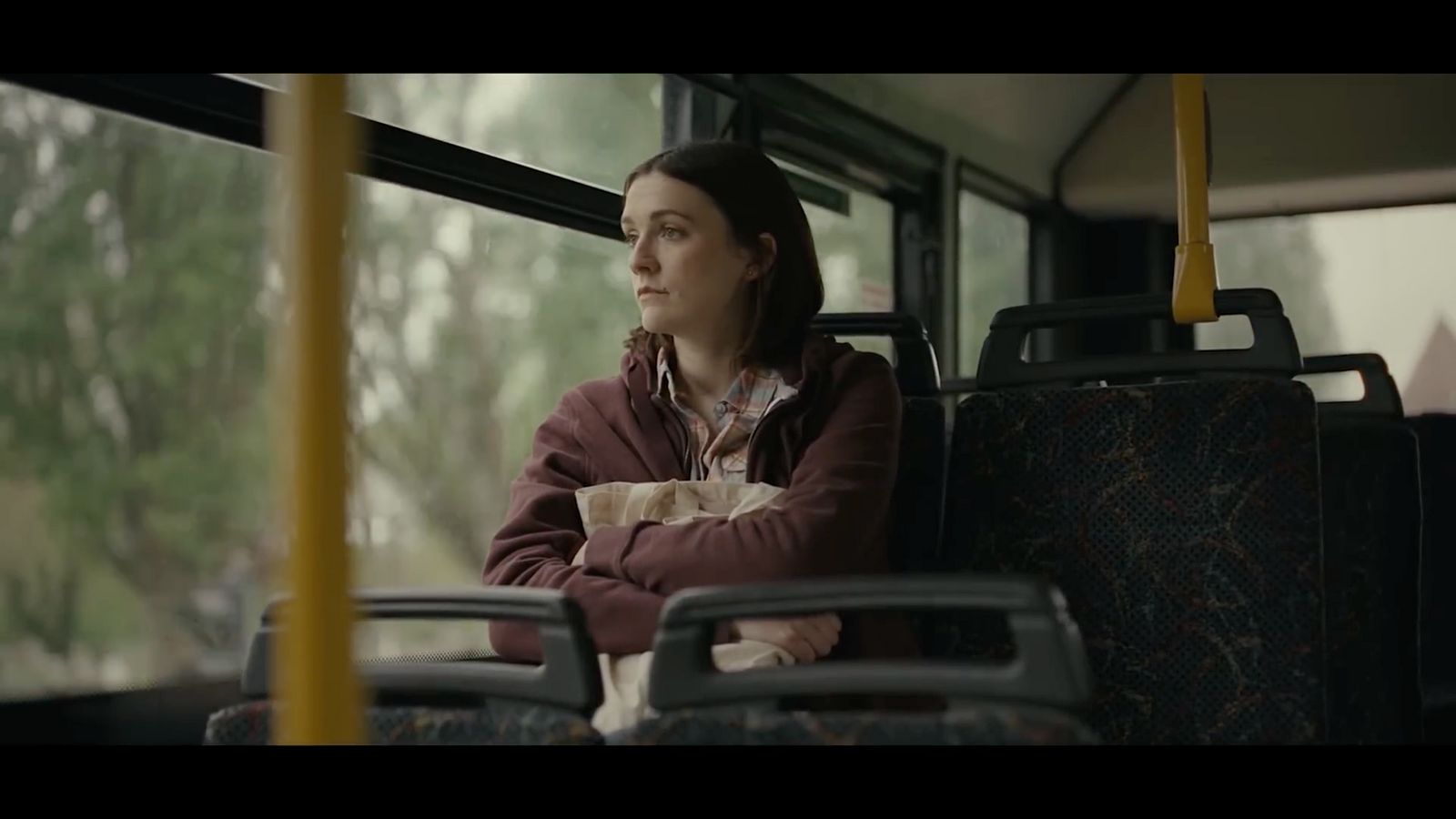 a woman sitting on a bus looking out the window