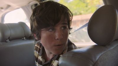 a young boy sitting in the back seat of a car