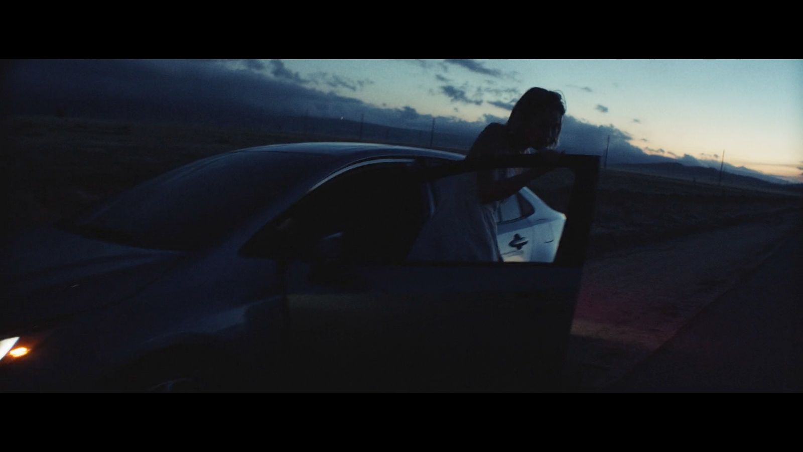 a woman sitting in a car looking out the window