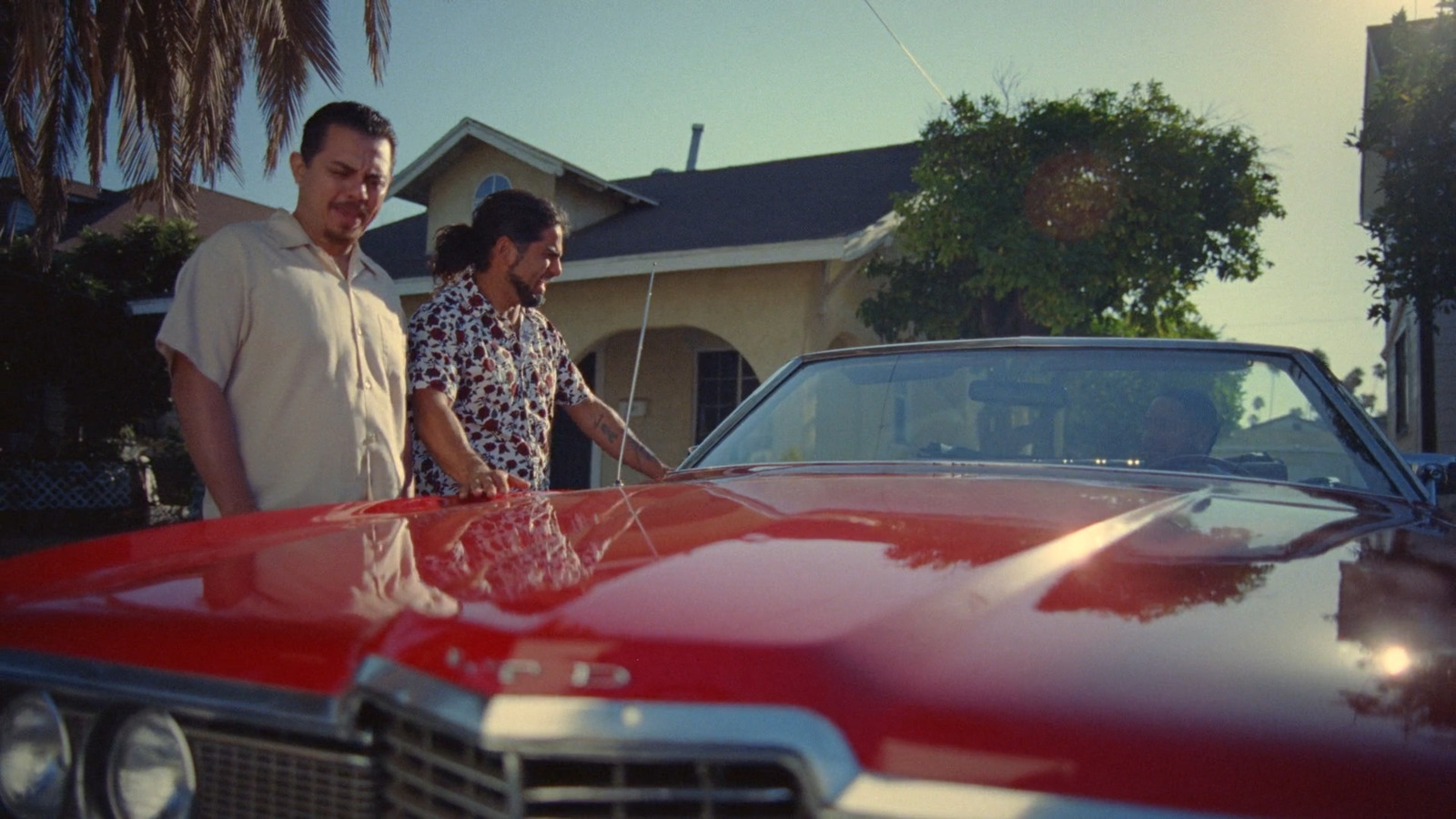 a man and a woman standing next to a red car